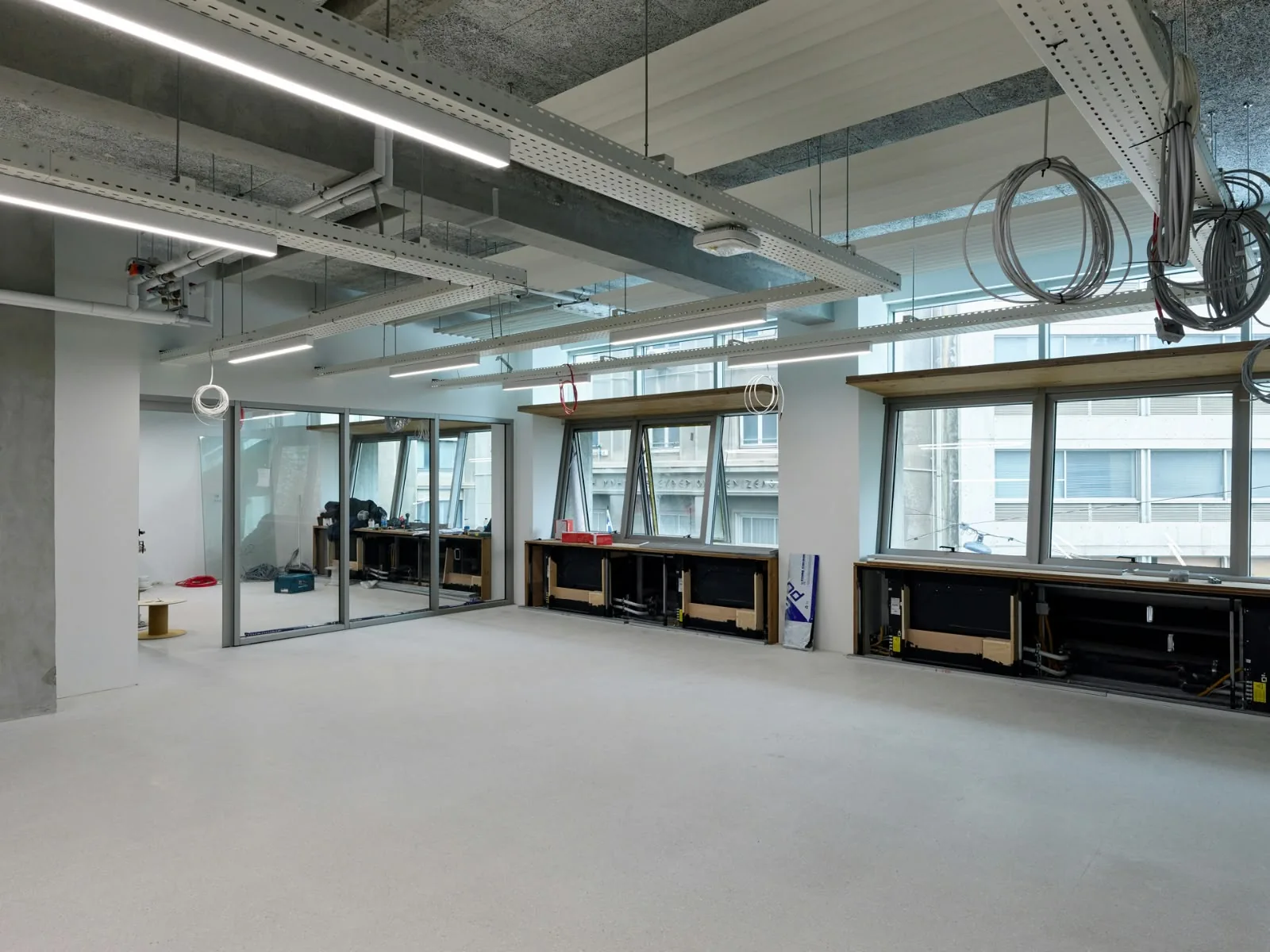An open floor under fit-out, glass partitions along the street side.