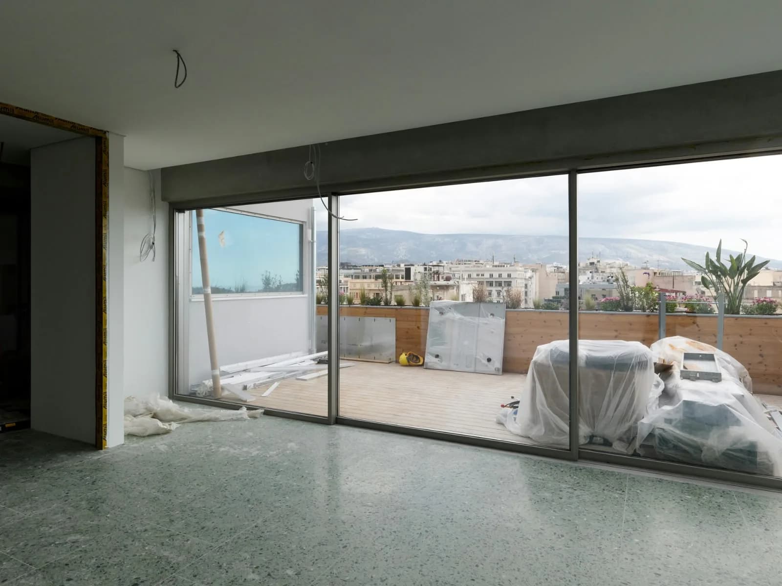 An upper floor opening onto its terrace, with the city beyond.