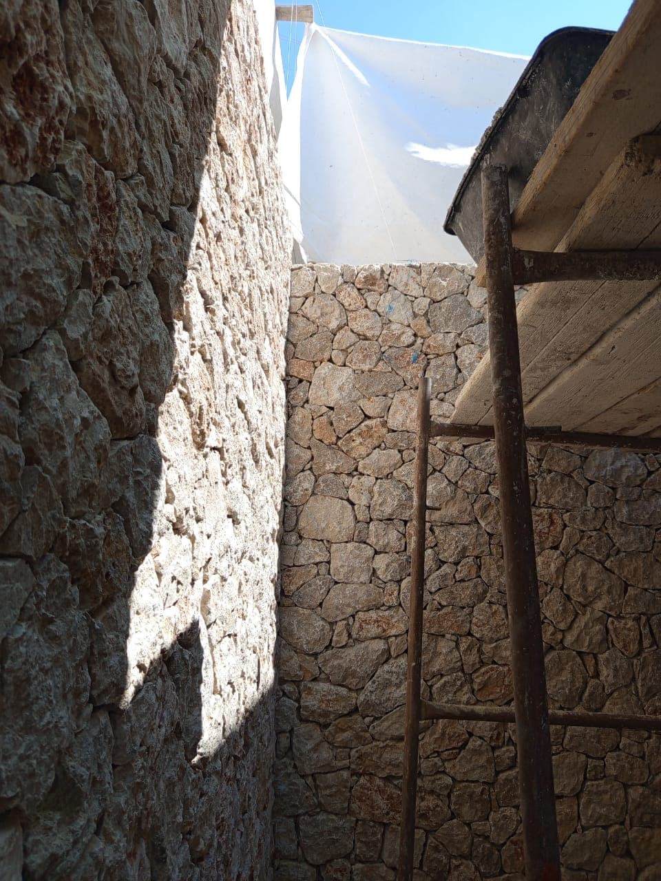 Dry-stone walling to the villa elevations, under construction.